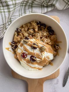 a bowl filled with ice cream, nuts and caramel drizzled on top