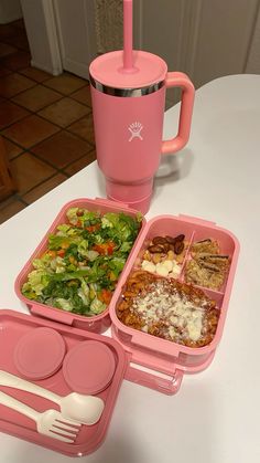 three plastic containers with food in them sitting on a table next to a fork and cup