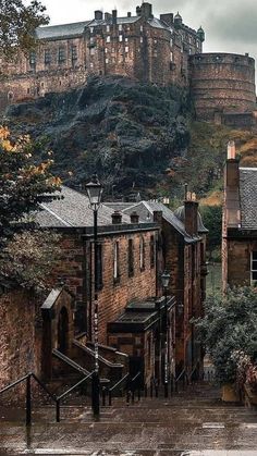 an old castle on top of a hill in the distance with stairs leading up to it