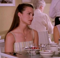 two women sitting at a table with cups and saucers