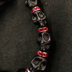 "If you're like me, you love skulls. So show your love with this skull bracelet! This bracelet features black howlite stone skulls and red stone crystal spacers, and is closed with a silver stainless steel lobster claw clasp. It comes in 3 sizes: Large - Fits wrists you to 7 1/2\" around Medium - Fits wrists up to 6 1/2\" around Small - Fits wrists up to 5 1/2\" around. If you need a different size, let me know and I will see what I can do. Make sure to check out my shop, PopBangBoom, for all so Red Gems, Skull Beads, Red Jewel, Howlite Stone, Skull Bracelet, Black Skulls, Beaded Skull, Goth Punk, Stone Crystal