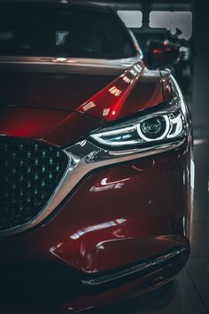 the front end of a red car in a showroom