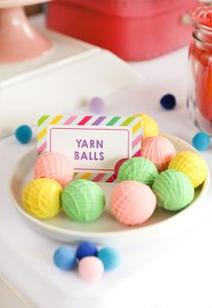 colorful candies are on a plate with a name tag that says yarn balls in front of them