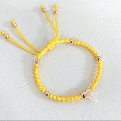 New. Stainless Steel Puffed Heart Ajustable Knotted Bracelet. Color Yellow. Handmade With 6mm Golden Stainless Steel Beads Enclosed With Knots On A Braided Cord Creating A Stylish Design. A Focal Stainless Steel Puffed Heart Is The Star Of This Bracelet. Adjustable With Macrame Sliding Closure. Wear It Alone Or Create Stacks Combinations With More Bracelets. Perfect Gift For Valentines Day, Mother’s Day, Christmas, Birthdays, Anniversaries Or Simply For Yourself. Adjustable Yellow Jewelry With Heart Beads, Adjustable Yellow Gold Bracelet With Heart Beads, Yellow Adjustable Friendship Bracelets As Gift, Yellow Beaded Bracelets With Sliding Knot As Gift, Yellow Beaded Bracelets With Sliding Knot For Gifts, Yellow Beaded Bracelet With Sliding Knot As Gift, Yellow Friendship Bracelets With Round Beads, Adjustable Yellow Gold Heart Bead Bracelet, Adjustable Yellow Gold Heart Bracelet With Heart Beads