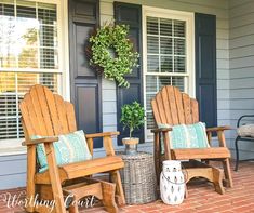 two wooden chairs sitting on top of a brick patio