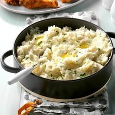 a pan filled with mashed potatoes on top of a table next to other dishes