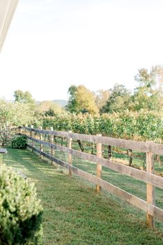 a wooden fence in the grass next to a house