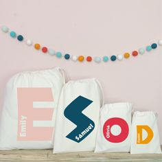 three bags with different logos on them sitting next to a string of colorful balls and beads