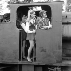 two women and a man standing in the open door of a train caboose