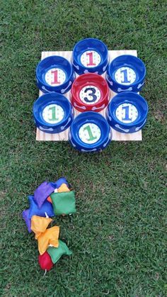 a set of frisbees with numbers on them sitting in the grass next to a game board