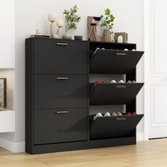 a black shoe rack with shoes on it next to a white wall and wooden floor