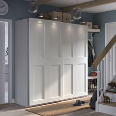 a room with some white doors in it and a clock on the wall above them