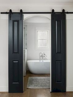 an open door leading to a bathroom with a tub