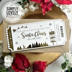 a ticket for santa claus in lapland on a table with poinsettis