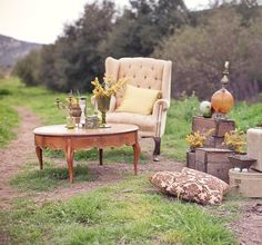 a chair and table sitting on the side of a dirt road next to a field