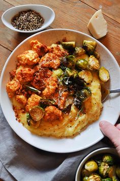 a white plate topped with brussel sprouts next to bowls of food