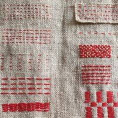 a close up view of a red and white pattern on a piece of linen material