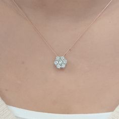 a woman wearing a necklace with three diamonds on it's center and two small flowers in the middle