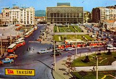 an old photo of a city street with cars, buses and people walking around it