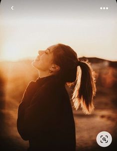 a woman with long hair standing in the sun