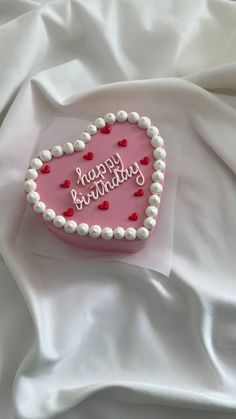 a heart shaped cake with happy birthday written on it