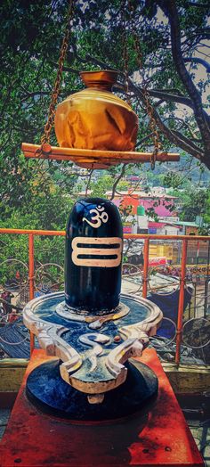 a bell on top of a table in front of a tree