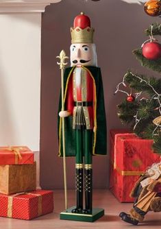 a wooden nutcracker standing in front of a christmas tree with presents under it