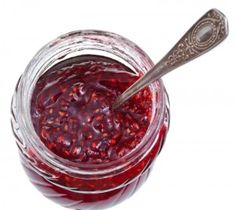 a glass jar filled with cranberry sauce and a spoon