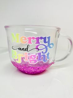 a glass cup with merry and bright written on the inside is sitting on a white surface