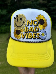 a person wearing a yellow and white hat that says no bad vibes