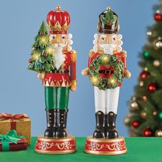 two nutcrackers are standing next to a christmas tree