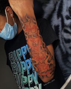 a man with a tattoo on his arm wearing a face mask