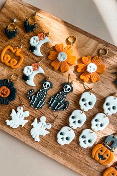 a wooden board topped with lots of halloween themed keychains and decorations on top of it