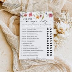 a white and black checklist sitting on top of a table next to some flowers