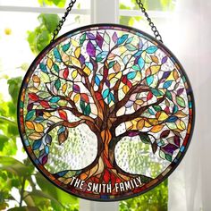 a stained glass tree with the words, the smith family on it hanging in front of a window