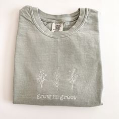 "My absolute favorite style of tee! This  comfort colors \"grow in grace\"' tee is stitched in a delicate handwriting font and  can be customized to your preferred thread color.  Please wash on cold and dry on low.  If you are wanting a different design, wording, or a different clothing style, please send me a message so we can discuss the details. Please include thread color at checkout If you need this order rushed, please add these to your cart: https://www.etsy.com/listing/1043569716/rush-my-order-for-t-shirts?ref=shop_home_active_19&frs=1 Rush my order + Priority shipping, click here: https://www.etsy.com/listing/1043567696/rush-my-order-priority-shipping-for-t?ref=shop_home_active_35&frs=1" Faith Clothing, Grow In Grace, Baggy Fits, Floral Embroidery, Tshirt Colors, Cotton Tee, Comfort Colors, Short Sleeve Tee, Relaxed Fit