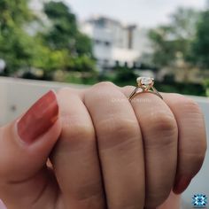 a woman's hand holding an engagement ring