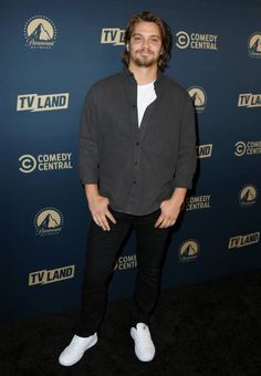 a man standing in front of a tv land sign at the comedy central awards event