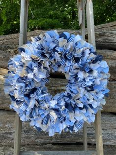 a blue and white wreath sitting on top of a wooden ladder