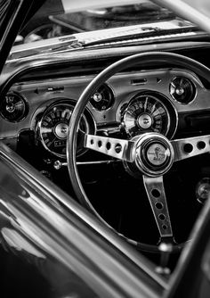 the interior of an old classic car with gauges and dash boards on display in black and white