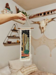 a person holding up a banner with a cactus on it in front of a bed