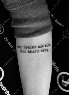 a person with a tattoo that reads our brains are slow but what's okay