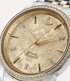 The design of our Wallace watch echoes the interiors of the Wallace Collection, complete with a two-toned bracelet, Swarovski crystal details and an intricate jacquard-etched dial. The piece receives an orb motif at the twelve o'clock position, synonymous with Vivienne's vision of launching tradition into the future. Elegant Gold Engraved Watches, Luxury Gold Watches With Rotating Bezel, Luxury Gold Diamond Watch With Rotating Bezel, Luxury Silver Engraved Watches, Luxury Engraved Gold Jewelry And Watches, Luxury Engraved Round Watch, Elegant Gold Diamond Watch With Rotating Bezel, Elegant Gold Jewelry And Watches With Skeleton Dial, Wallace Collection