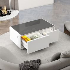 a white coffee table with drawers on it in a living room next to a fire place