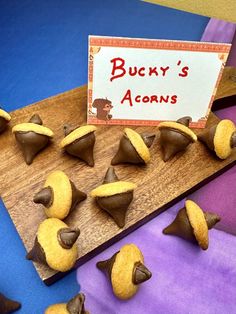 some cookies are on a wooden board with a sign that says bucky's acorns