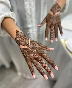 a woman's hand with henna tattoos on it