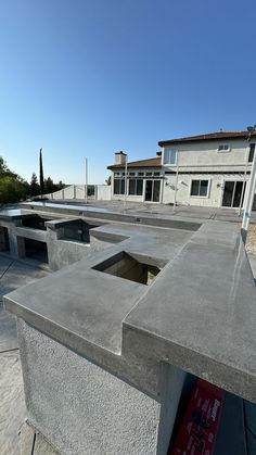 concrete benches are lined up in front of a building with a red sign on it