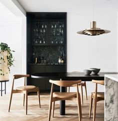 a dining room table with chairs and a black cabinet