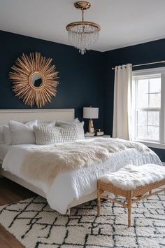 a bedroom with blue walls, white bedding and a chandelier hanging from the ceiling