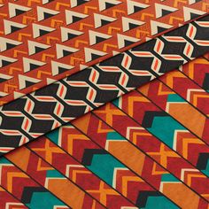 three different colored ties are stacked on top of each other, one is orange and the other is blue